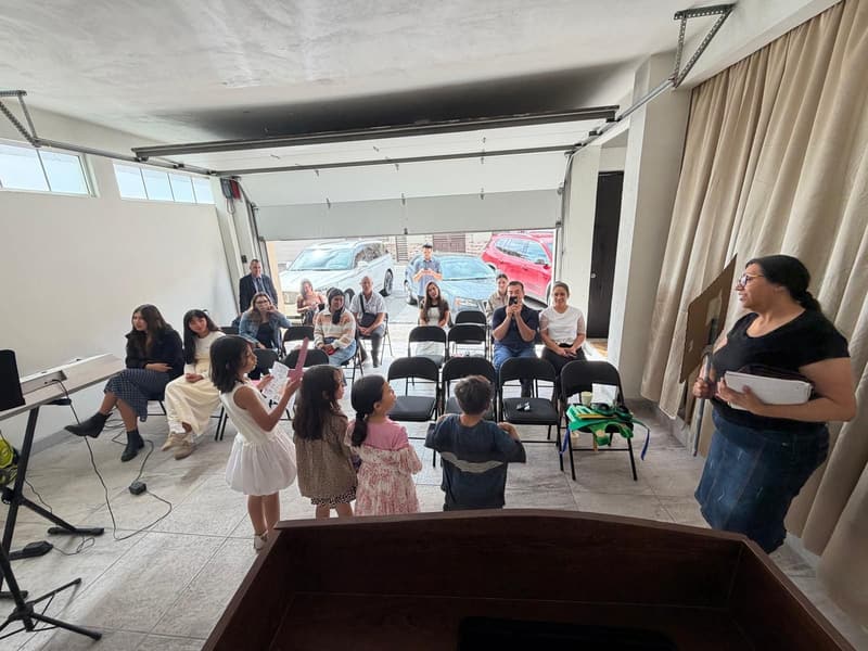 Niños reunidos al frente para el mensaje de los niños en la iglesia de Tijuana, con adultos sentados detrás.